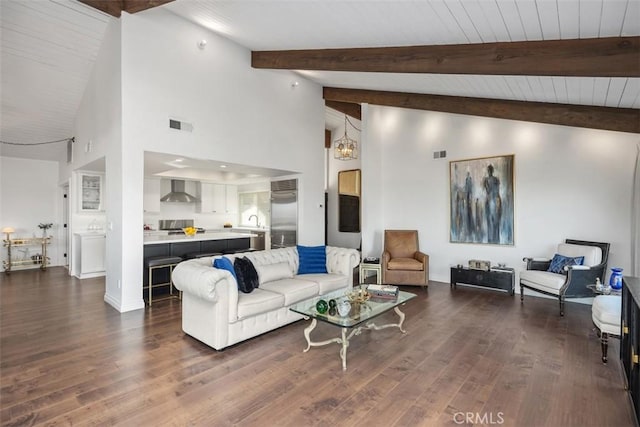 living room featuring visible vents, lofted ceiling with beams, dark wood-type flooring, a chandelier, and baseboards