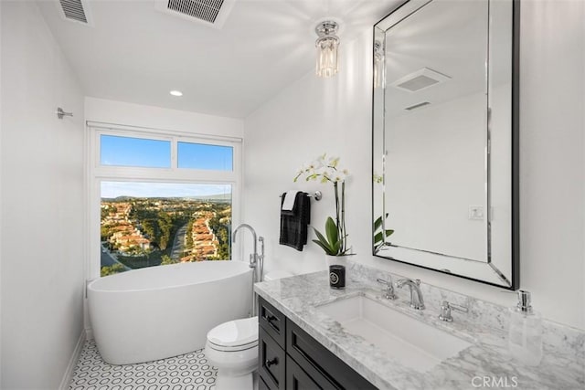 full bath featuring toilet, a soaking tub, visible vents, and vanity