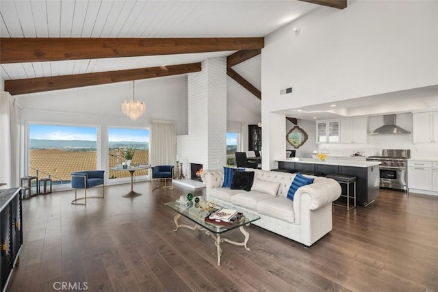 living room with a chandelier, dark wood-style flooring, visible vents, and a fireplace