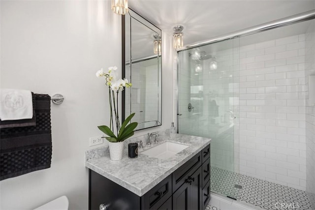 bathroom featuring toilet, a shower stall, and vanity