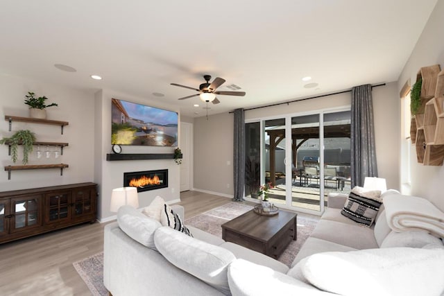 living room with ceiling fan and light wood-type flooring