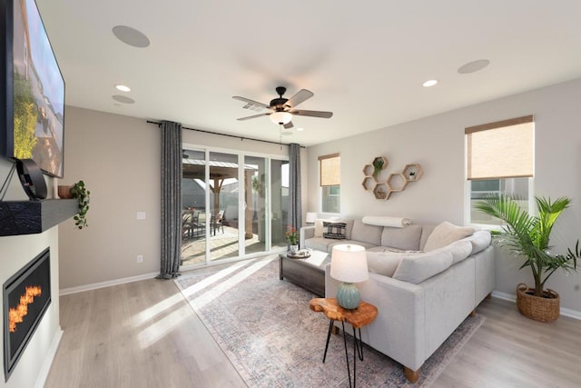 living room with ceiling fan and light hardwood / wood-style floors