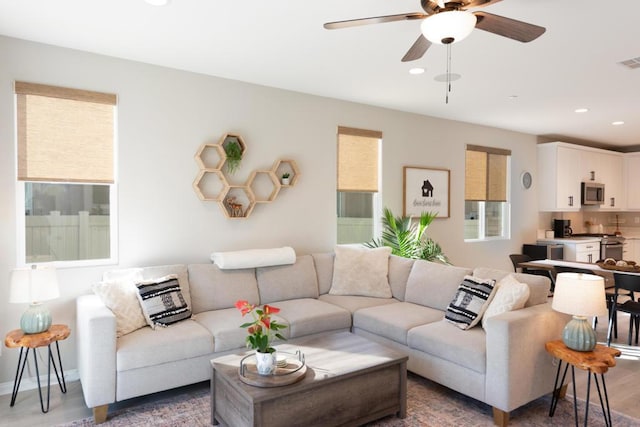 living room featuring ceiling fan, a wealth of natural light, and wood-type flooring