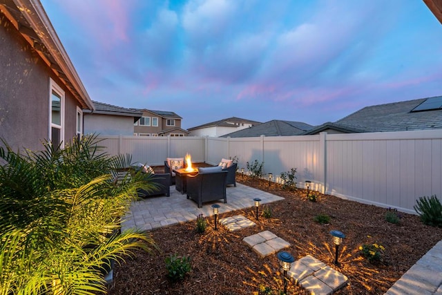 patio terrace at dusk featuring a fire pit