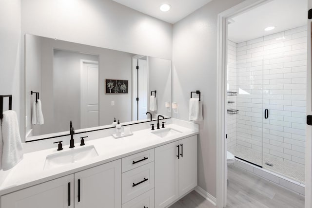 bathroom with toilet, vanity, hardwood / wood-style floors, and walk in shower