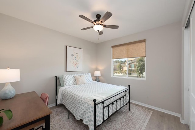 bedroom featuring light wood-type flooring, ceiling fan, and a closet