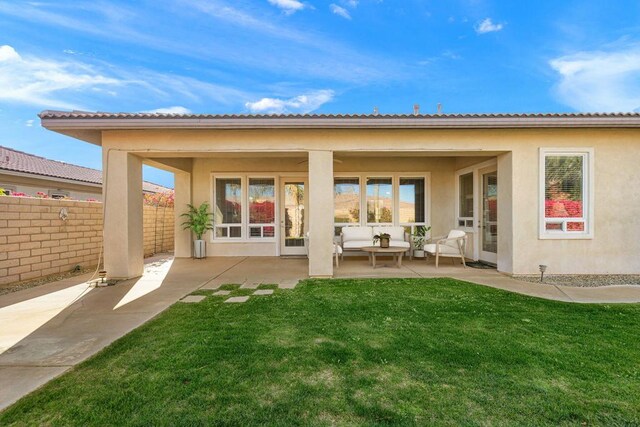 rear view of property featuring a lawn, a patio area, and outdoor lounge area