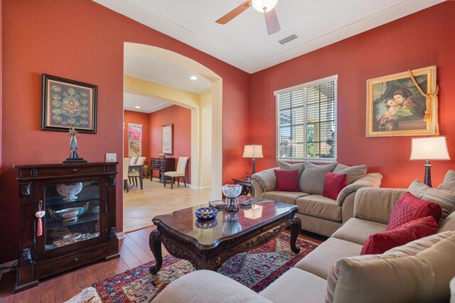 living room with ceiling fan, ornamental molding, and light hardwood / wood-style floors