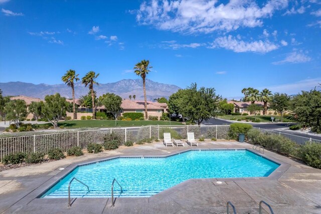 view of swimming pool featuring a mountain view and a patio