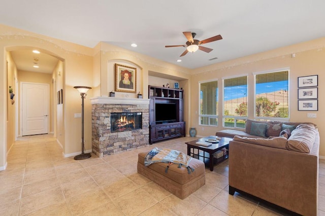 living room with ceiling fan, light tile patterned flooring, and a fireplace