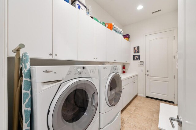 washroom with cabinets, light tile patterned flooring, and washing machine and clothes dryer