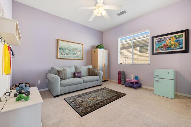 carpeted living room with ceiling fan