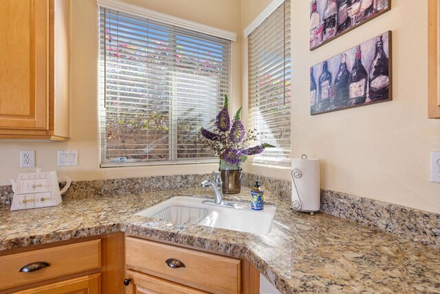 kitchen featuring sink and light stone counters