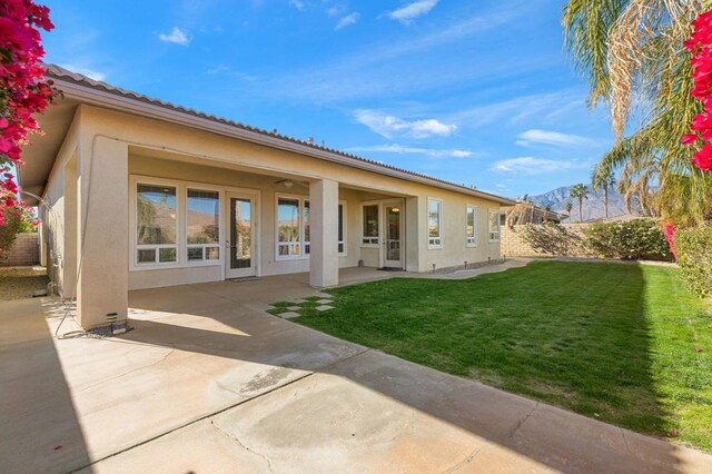 back of house with a patio area and a yard