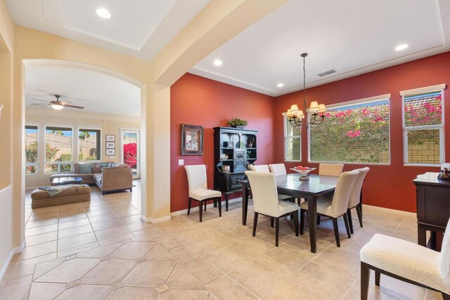 tiled dining area featuring ceiling fan with notable chandelier