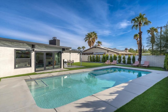 view of pool featuring a lawn and a patio area