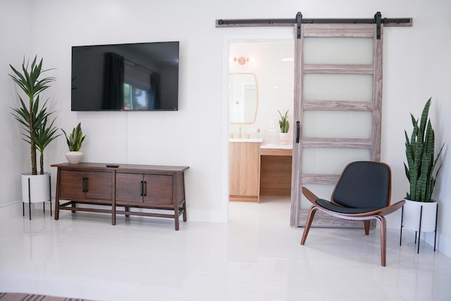 sitting room featuring a barn door and light tile patterned floors