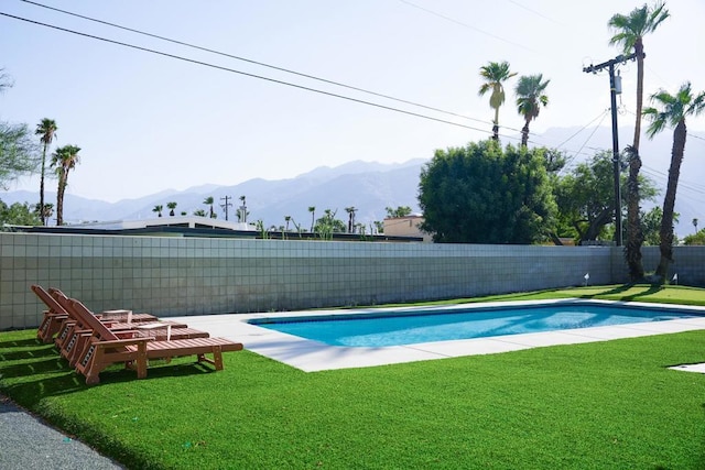 view of pool featuring a mountain view and a yard