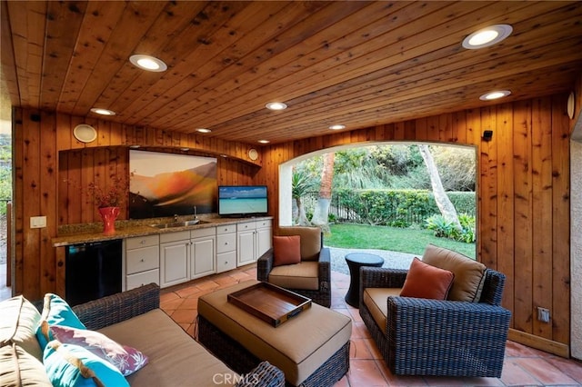 living room featuring light tile patterned floors, wood walls, wooden ceiling, and recessed lighting