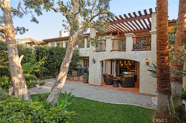 rear view of house with a balcony, a pergola, an outdoor hangout area, and a patio