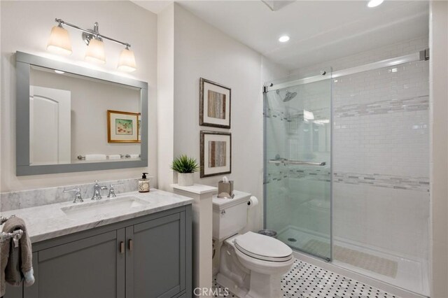 bathroom featuring a stall shower, vanity, toilet, and recessed lighting