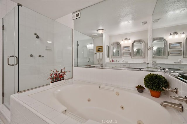 bathroom with a textured ceiling and shower with separate bathtub