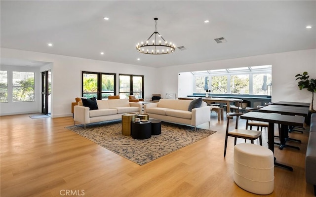 living room featuring light wood-type flooring and a chandelier