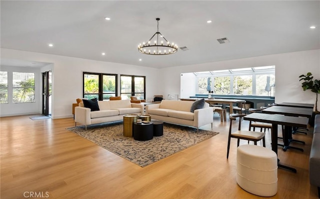 living room with a healthy amount of sunlight, light wood-style flooring, and visible vents