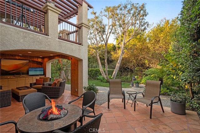 view of patio / terrace with an outdoor fire pit, outdoor dining area, and a sink