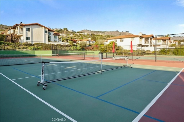 view of sport court with fence and a residential view