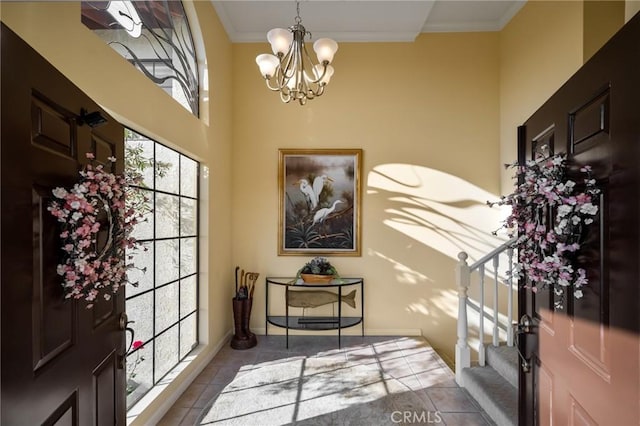 tiled foyer with an inviting chandelier and crown molding