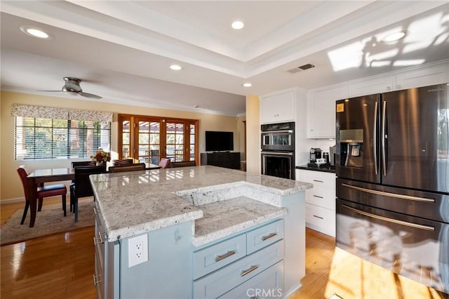 kitchen featuring white cabinets, a center island, fridge with ice dispenser, and black double oven