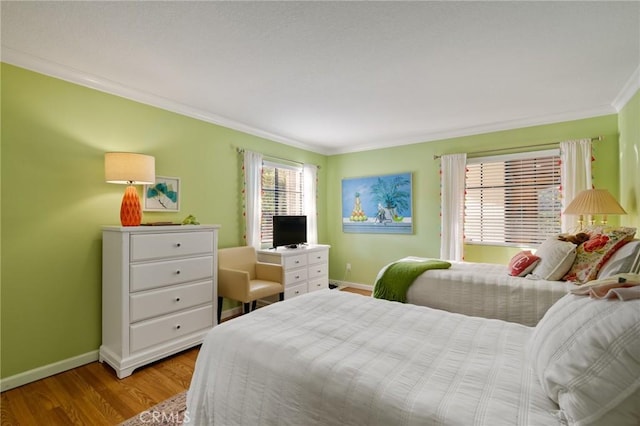 bedroom featuring ornamental molding and light hardwood / wood-style flooring