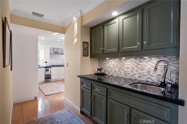 kitchen with sink, light hardwood / wood-style flooring, decorative backsplash, dark stone counters, and wine cooler