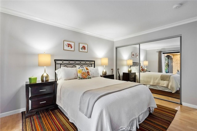 bedroom with hardwood / wood-style floors, a closet, and crown molding