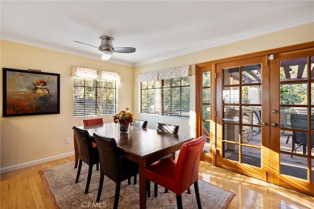 dining area with a ceiling fan, crown molding, light wood-style flooring, and baseboards