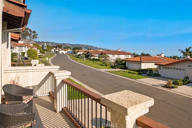 balcony featuring a residential view and a mountain view