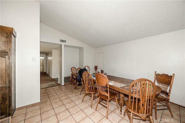 tiled dining room with lofted ceiling