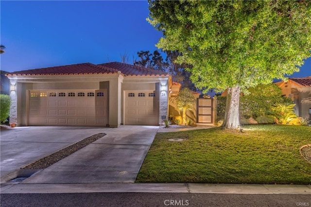 view of front of house featuring a front yard, concrete driveway, a tiled roof, and an attached garage