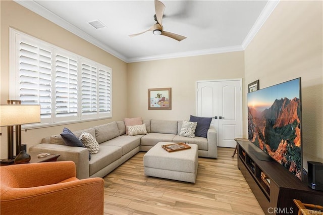 living room with ceiling fan, light wood-style flooring, visible vents, and crown molding