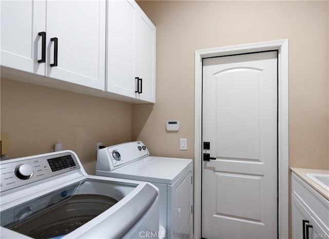 clothes washing area featuring cabinet space and separate washer and dryer