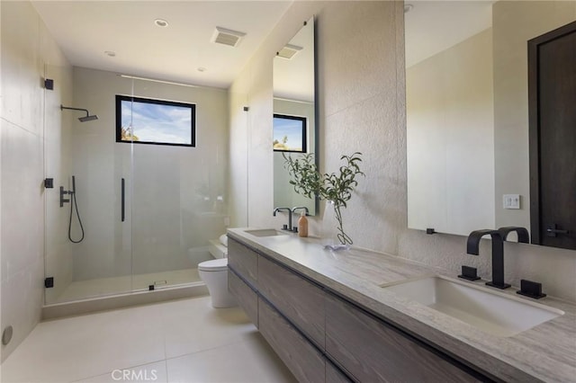 bathroom featuring tile patterned flooring, vanity, toilet, and walk in shower