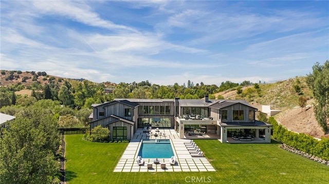 rear view of house featuring a yard and a patio