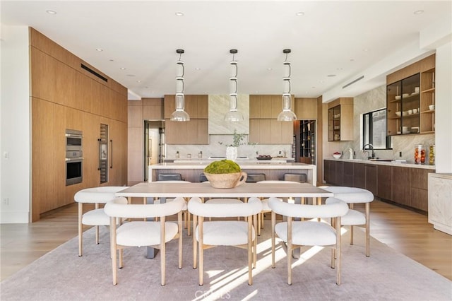 kitchen featuring a spacious island, pendant lighting, and light hardwood / wood-style floors