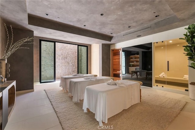 bedroom featuring a tray ceiling and expansive windows