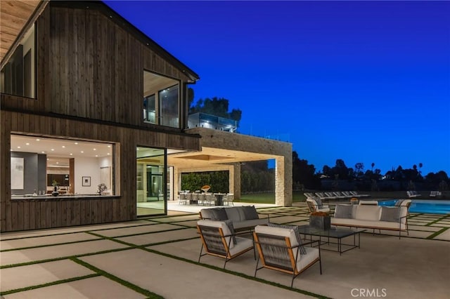 patio at twilight featuring an outdoor hangout area