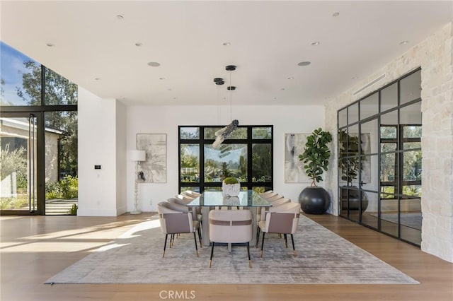 dining room featuring expansive windows, light hardwood / wood-style floors, and french doors