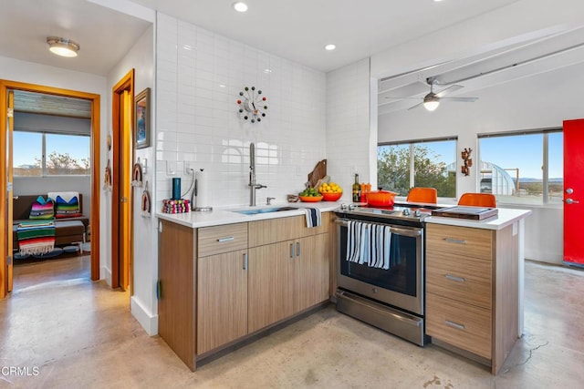 kitchen with sink, decorative backsplash, ceiling fan, kitchen peninsula, and stainless steel electric range