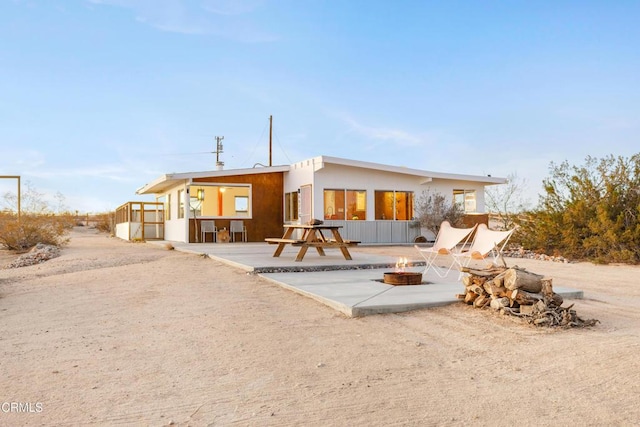 rear view of house featuring a patio area and an outdoor fire pit