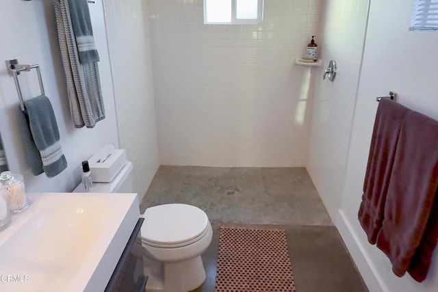 bathroom featuring vanity, toilet, and tiled shower